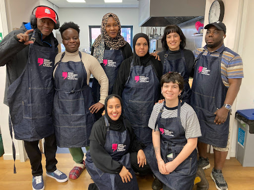 Group photo of Govan Community Project volunteers wearing GCP branded aprons